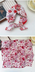 Detail of vintage red floral square scarf tied in a bow on a French aesthetic table