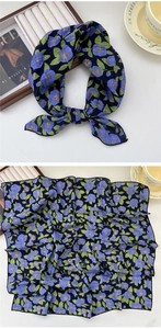 Detailed view of dark blue camellia floral print on silk square scarf with hand-rolled edges