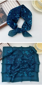 Detail of navy blue linen-silk square scarf featuring abstract floral patterns and geometric borders