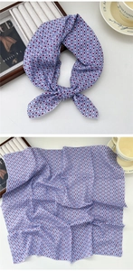 Detailed pattern of geometric silk scarf with purple diamond motifs and fabric texture
