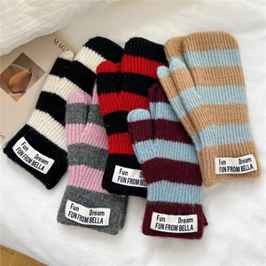 Mitaines en tricot rayé de différentes couleurs sur un fond blanc texturé doux