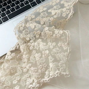 Detail of floral lace triangle scarf with delicate embroidery and scalloped edges