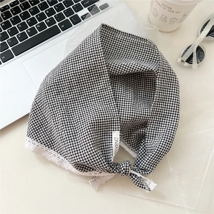 Detail of black and white checkered headband with lace trim and brand label