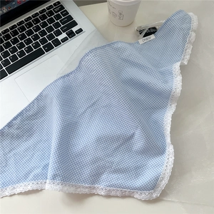 Close-up of blue checkered cotton scarf with delicate white lace edge and brand label