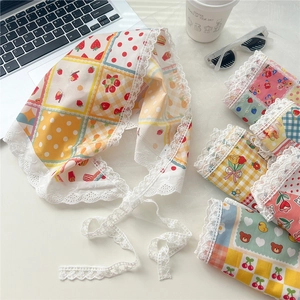 Lace-trimmed floral cotton headscarf with cute patterns on a minimalist white desk