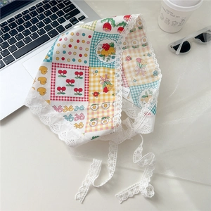 Detailed close-up of floral print cotton bandana with delicate white lace edges and ties