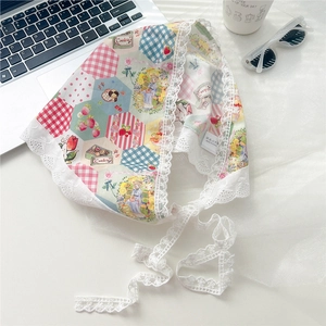 Detailed view of white cotton lace-edged bandana with patchwork strawberry and plaid patterns