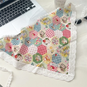 Flat lay of vintage floral cotton headscarf with lace trim on an aesthetic desk setup