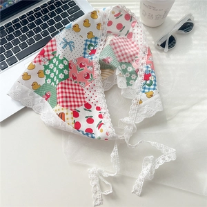 Close-up of retro floral lace cotton kerchief with cherry print and white crochet ties