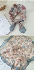 Detail of floral cotton linen scarf with soft blue hem and translucent flower print