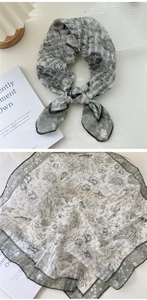 Detail view of light gray floral cotton linen scarf with green botanical prints