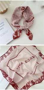Detail of red floral cotton linen scarf with striped pattern and elegant tied drape