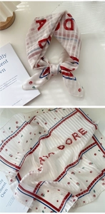 Detail of white cotton linen scarf featuring red floral print and J'ADORE typography