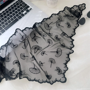 Detail of black lace triangle scarf with ginkgo leaf embroidery and scalloped edges