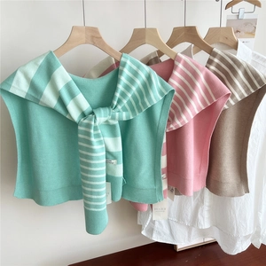 Striped knit shawl in mint, pink, and khaki shown layered over a white shirt on hangers