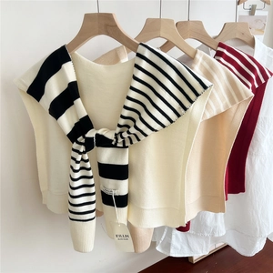 Detail of striped knitted shawls in various colors on wooden hangers for styling