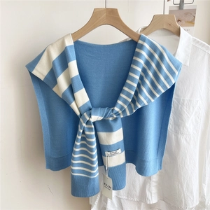 Close-up of blue and white striped knit shawl with FILLDI designer label and ribbed edges