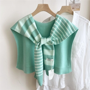 Detail of mint green striped knitted shawl tied over a white shirt with ribbed edges