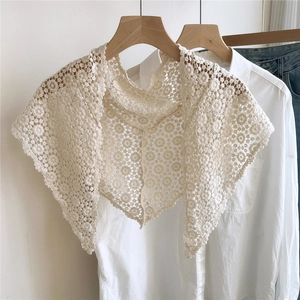 Macro detail of retro floral crochet pattern on cream cotton lace triangle shawl