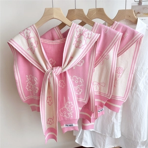 Detail of pink knitted floral shawl with bow patterns and sailor collar design