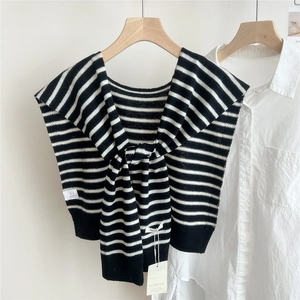 Detail showing high-quality black and white striped wool knit texture and washing labels