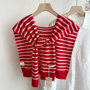 Detail of red and white striped 100% wool knit shawl draped over a classic white shirt