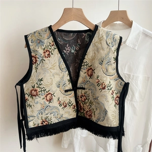 Detail of floral jacquard vest with vintage tassel hem and classic button closure