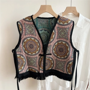 Detailed view of ethnic jacquard pattern vest with black tassel fringe and tie closure