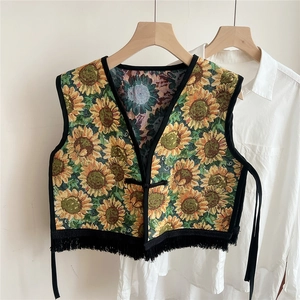 Detailed view of sunflower jacquard vest with V-neck and decorative black tassel fringe