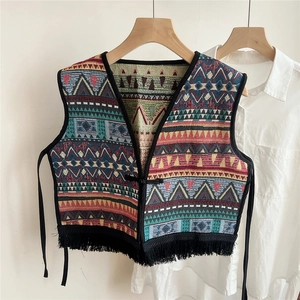Close-up of ethnic print vest with colorful geometric patterns and black tassel fringe