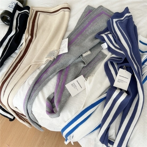 Detail of multi-color striped knitted shawls featuring soft texture and contrast edges
