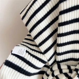 Close-up of striped ribbed knit fabric showing texture and wool blend material details
