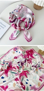 Gros plan détaillé d'un foulard en soie rose avec imprimés de lys et texture satinée