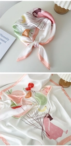 Détail d'un foulard en soie illustré avec une fille, des fruits et des bords roses