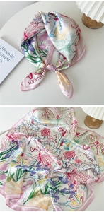 Vue détaillée du foulard en soie à fleurs avec papillons et texture soyeuse