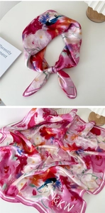 Détail d'un foulard en soie à imprimé floral avec motif d'oiseau et fini satiné