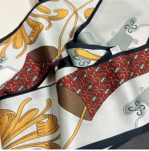 Macro detail of silk scarf showing vintage print texture and 100% mulberry silk tag