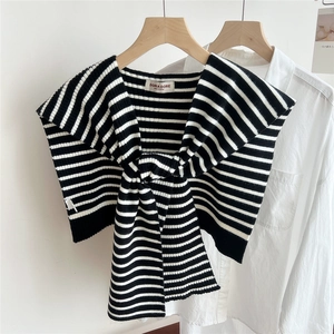 Close-up of black and white striped knitted shawl with woven Doria Dore brand label