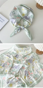 Détails d'un foulard en soie à fleurs avec bordure verte et texture satinée raffinée