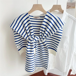 Detailed view of blue and white striped knit shawl with front knot and rib texture