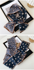 Detail of paisley print silk scarf in navy and grey showing texture and contrast borders
