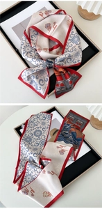 Detail of silk scarf showing classical lotus patterns and red rolled edges in a knot