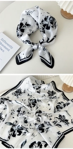 Détail d'un foulard en soie avec imprimé floral à l'encre noire et drapé élégant