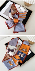 Close-up of silk scarf with equestrian horse and saddle patterns in retro orange and navy