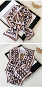 Detail of long silk scarf showing geometric weave pattern in brown, navy and beige