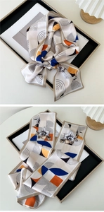 Detail of elegant floral silk scarf tied to a bag handle with geometric patterns