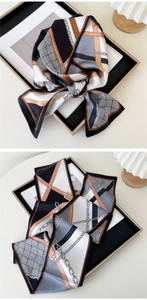 Detail of silk scarf with geometric chain prints in neutral black, white and brown tones