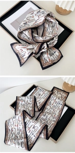 Detailed view of long silk twilly scarf with artistic letters and golden baroque patterns