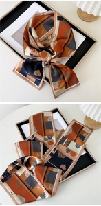 Detail of silk scarf with geometric caramel blue patterns and vintage rose floral print