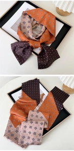 Detail of elegant slim silk scarf with brown polka dots and orange geometric patterns